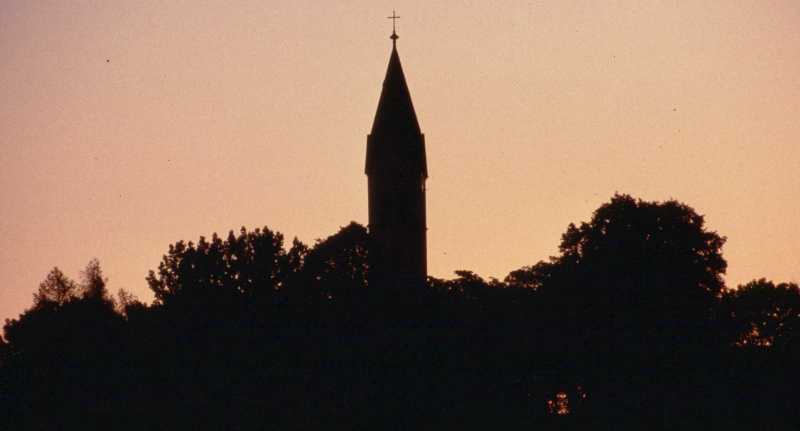 Siluette des Kirchturms beim Morgengrauen